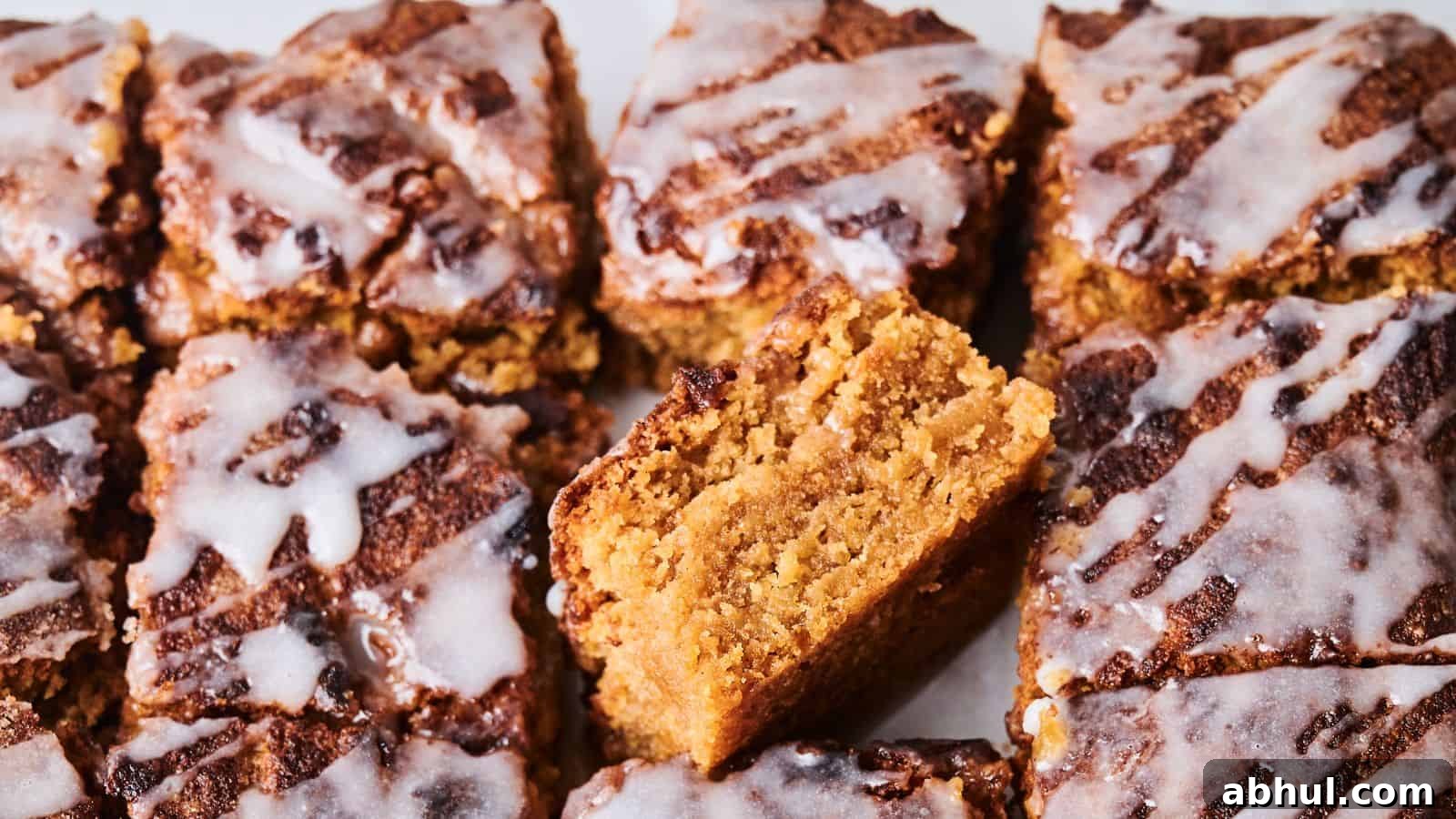 Close-up of sliced crumbly cakes topped with white icing. One piece is positioned vertically to show its texture.