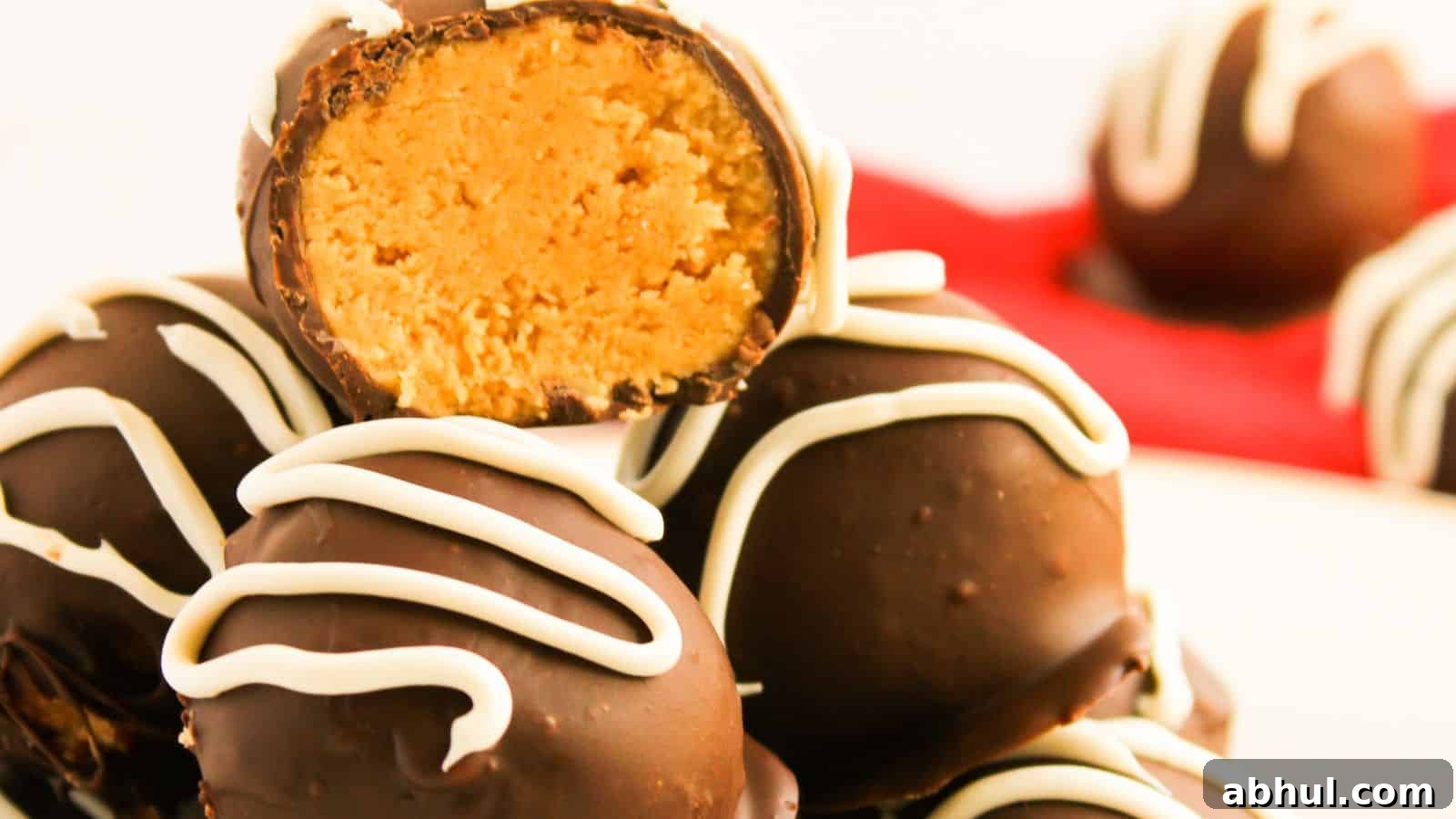 A stack of chocolate truffles with white icing, one cut open to reveal a peanut butter filling.