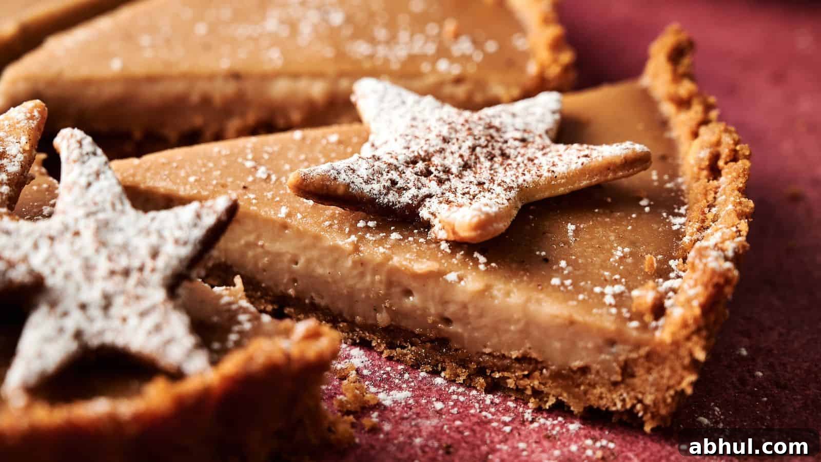 Close-up of a sliced pie with a crumb crust, topped with star-shaped cookies dusted with powdered sugar.