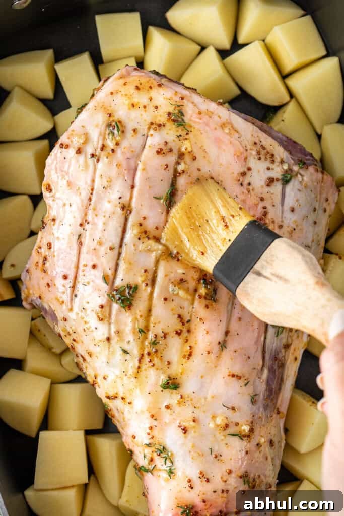 Brushing the lamb with the glaze.