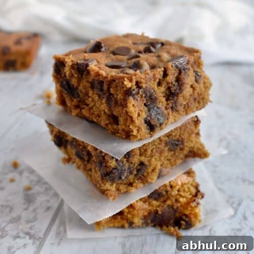 3 chocolate chip pumpkin blondies stack on top of each other.