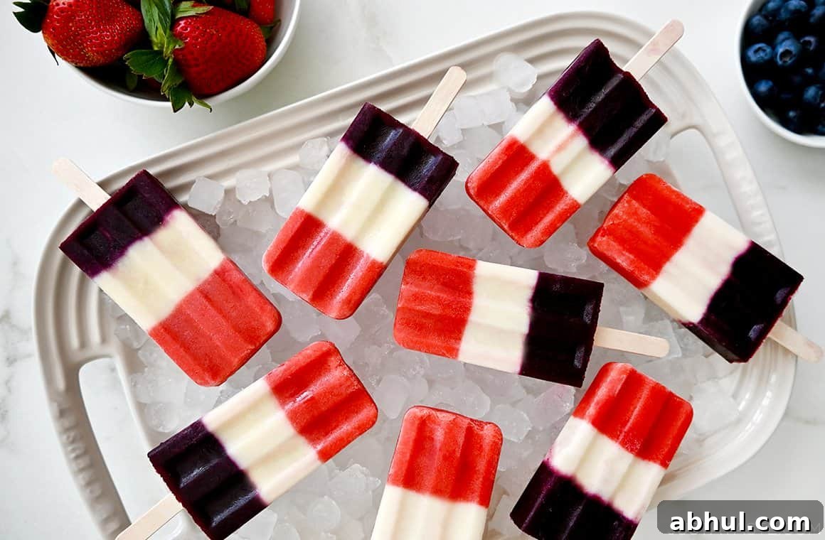 A white platter topped with crushed ice and red, white and blue popsicles