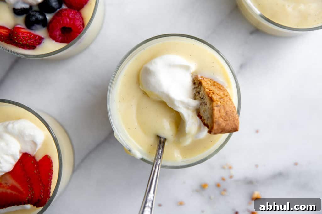 Homemade Gluten-Free Vanilla Pudding Recipe from Scratch 2 Close up of a bowl of vanilla pudding topped with whipped cream and a biscotti.