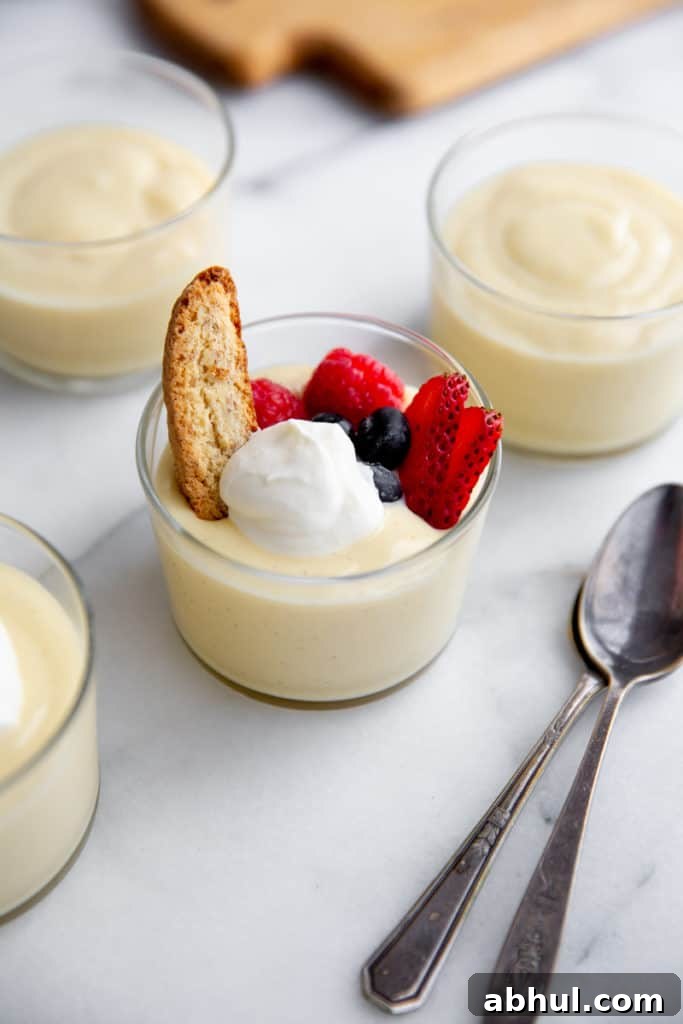 Homemade Gluten-Free Vanilla Pudding Recipe from Scratch 9 Vanilla pudding in glass jars topped with whipped cream, berries and biscotti.