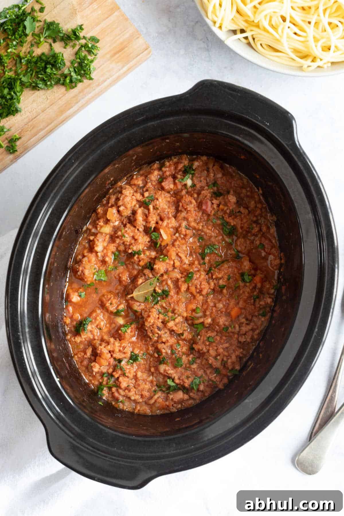 Slow Cooker Pork Ragu: Tender Slow-Braised Pork Ragù Recipe 11 Slow cooker pork mince ragu garnish with parsley.