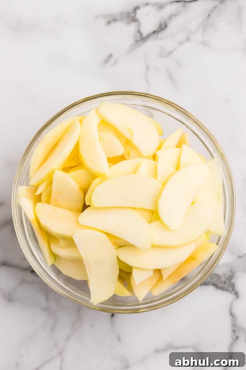 sliced apples in large glass bowl.