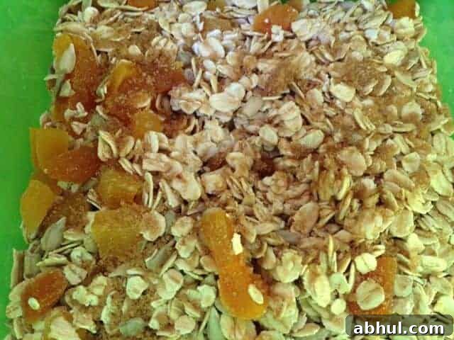 Green bowl of oatmeal, dried apricots, soymilk, and brown sugar.