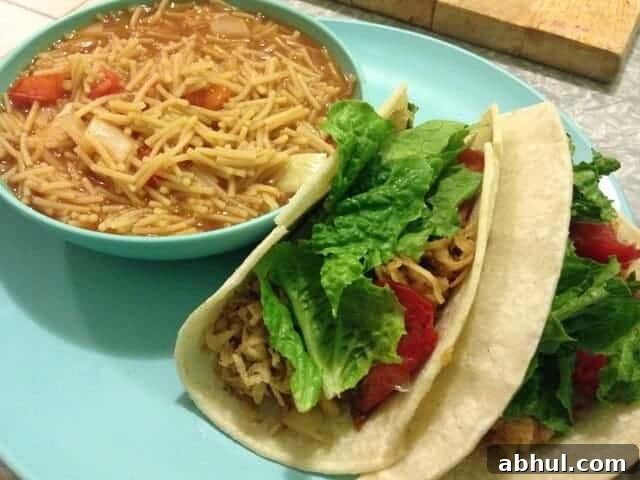 A small bowl of fideo pasta next to two sweet potato tacos.