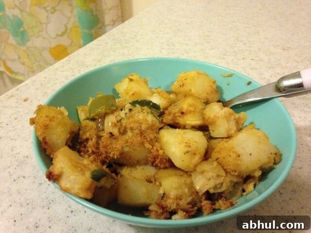 Small bowl of zucchini potato casserole topped with bread crumbs.