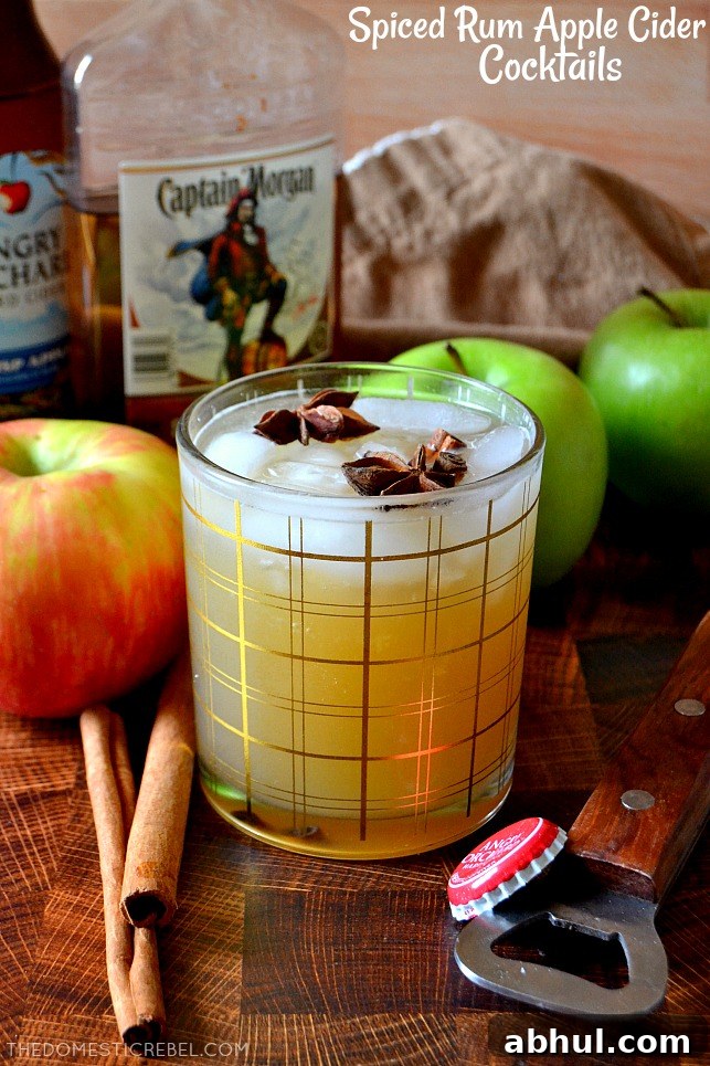 Spiced Rum Apple Cider Cocktail on a wooden board with rum and apples in the background