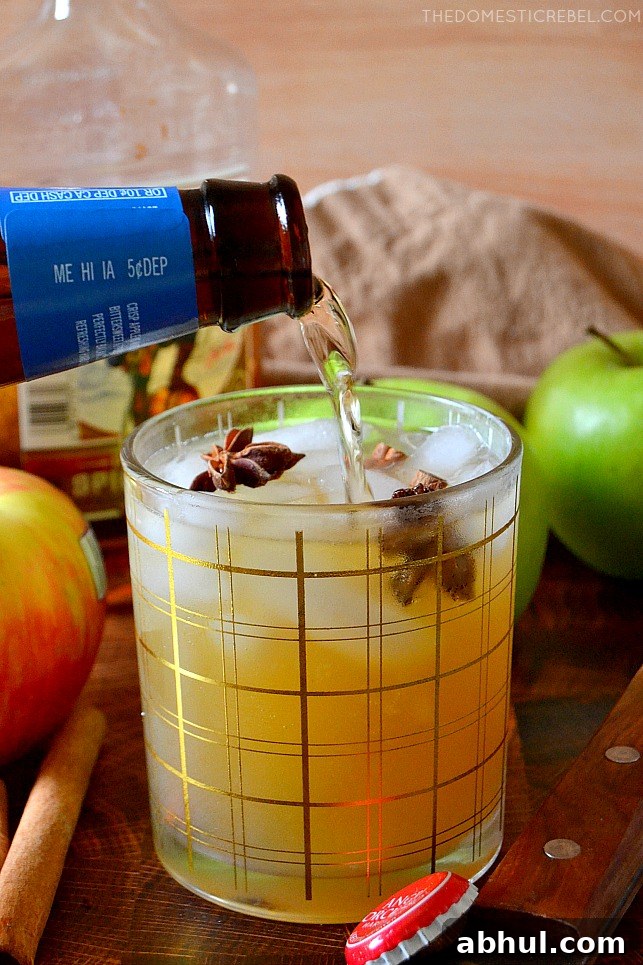 Photo of author pouring apple cider beer into a cocktail glass
