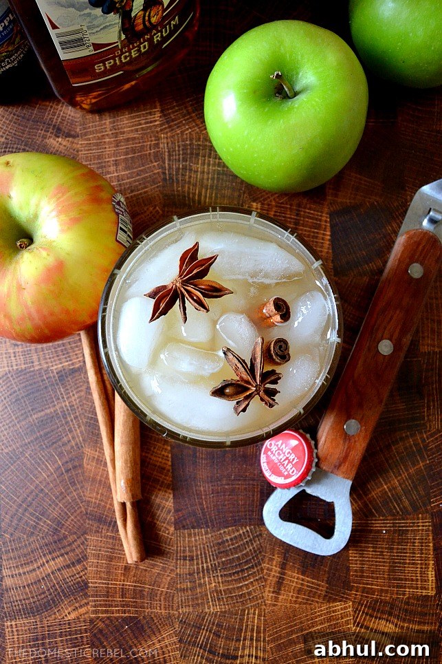 Aerial shot of apple cider cocktail on wood background with apples