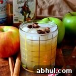 Spiced Rum Apple Cider Cocktail with apples and cinnamon sticks