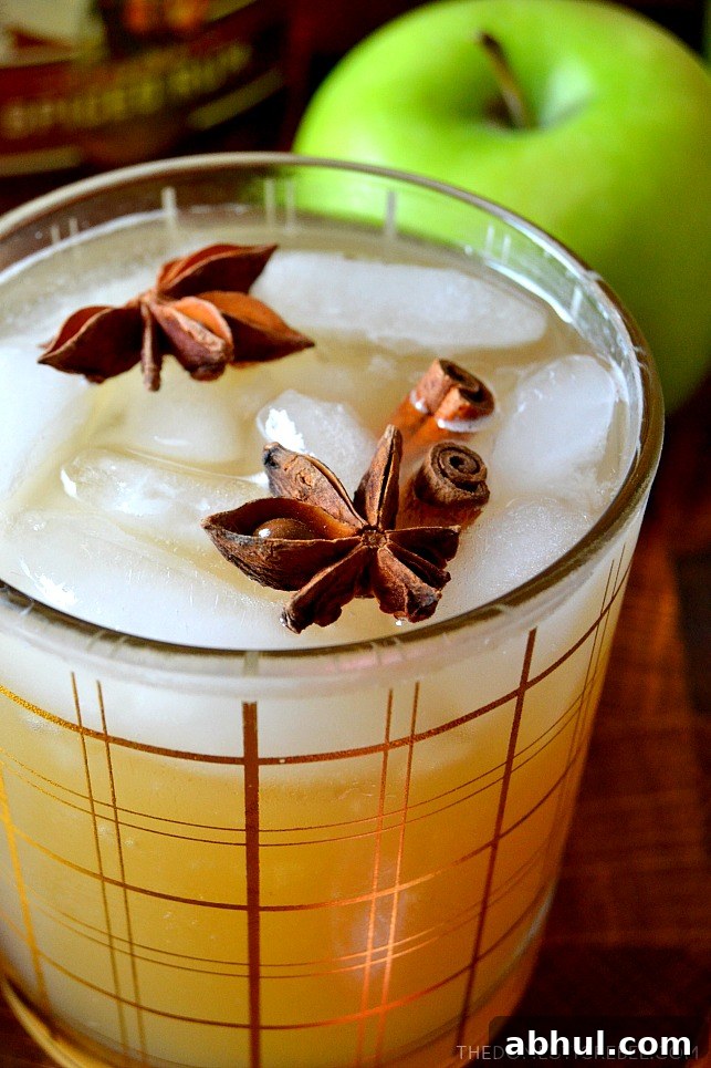 Super closeup of an apple cider cocktail with green apple in background