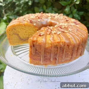 Pumpkin Snickerdoodle Bundt Cake, sliced, on a cake pedestal.