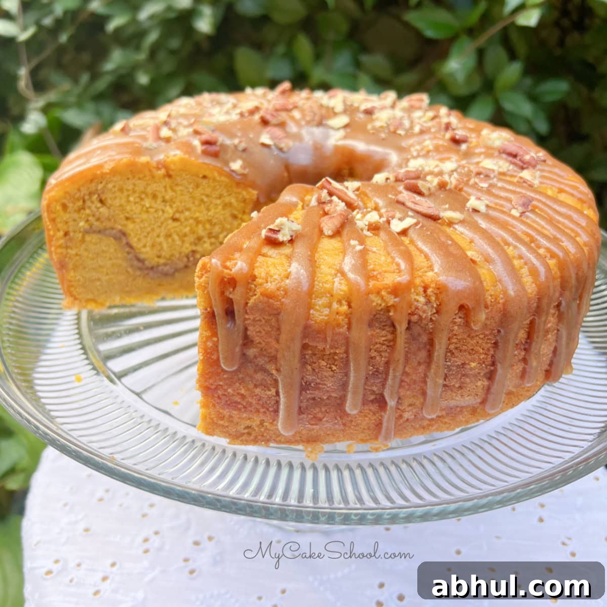 Pumpkin Snickerdoodle Bundt Cake, sliced, on a cake pedestal.