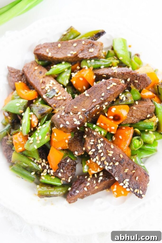 steak and vegetable stir fry on white plate 
