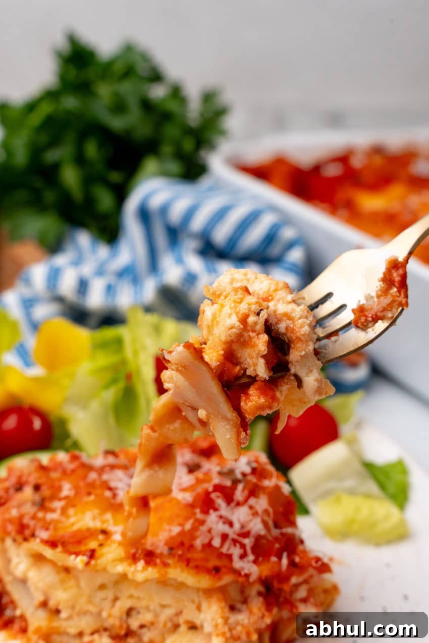 a silver fork holding up a piece of lasagna rosa