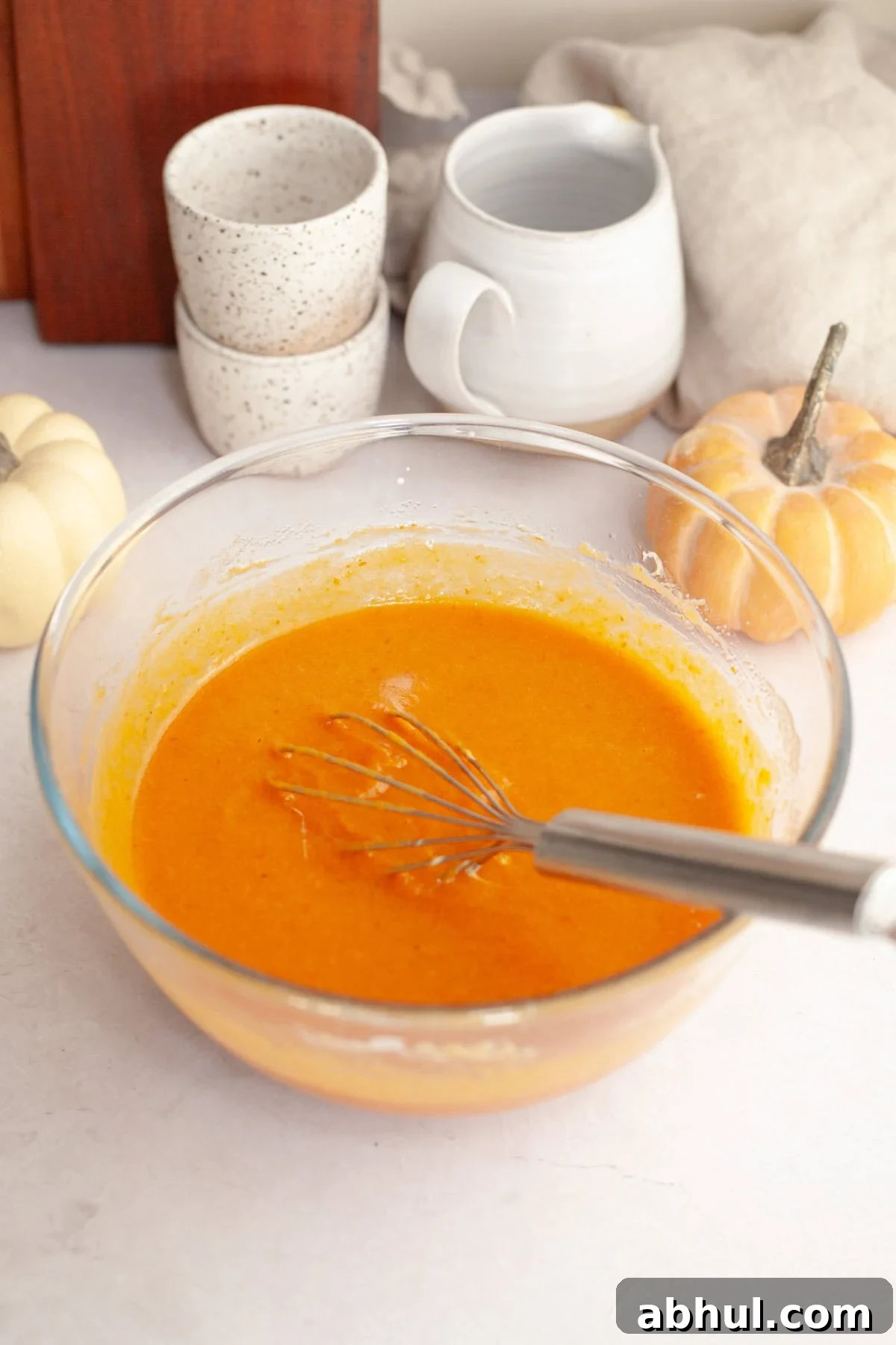 One-Bowl Pumpkin Sour Cream Muffins: Moist Fall Recipe 4 Pumpkin muffin batter in a glass bowl with a whisk.