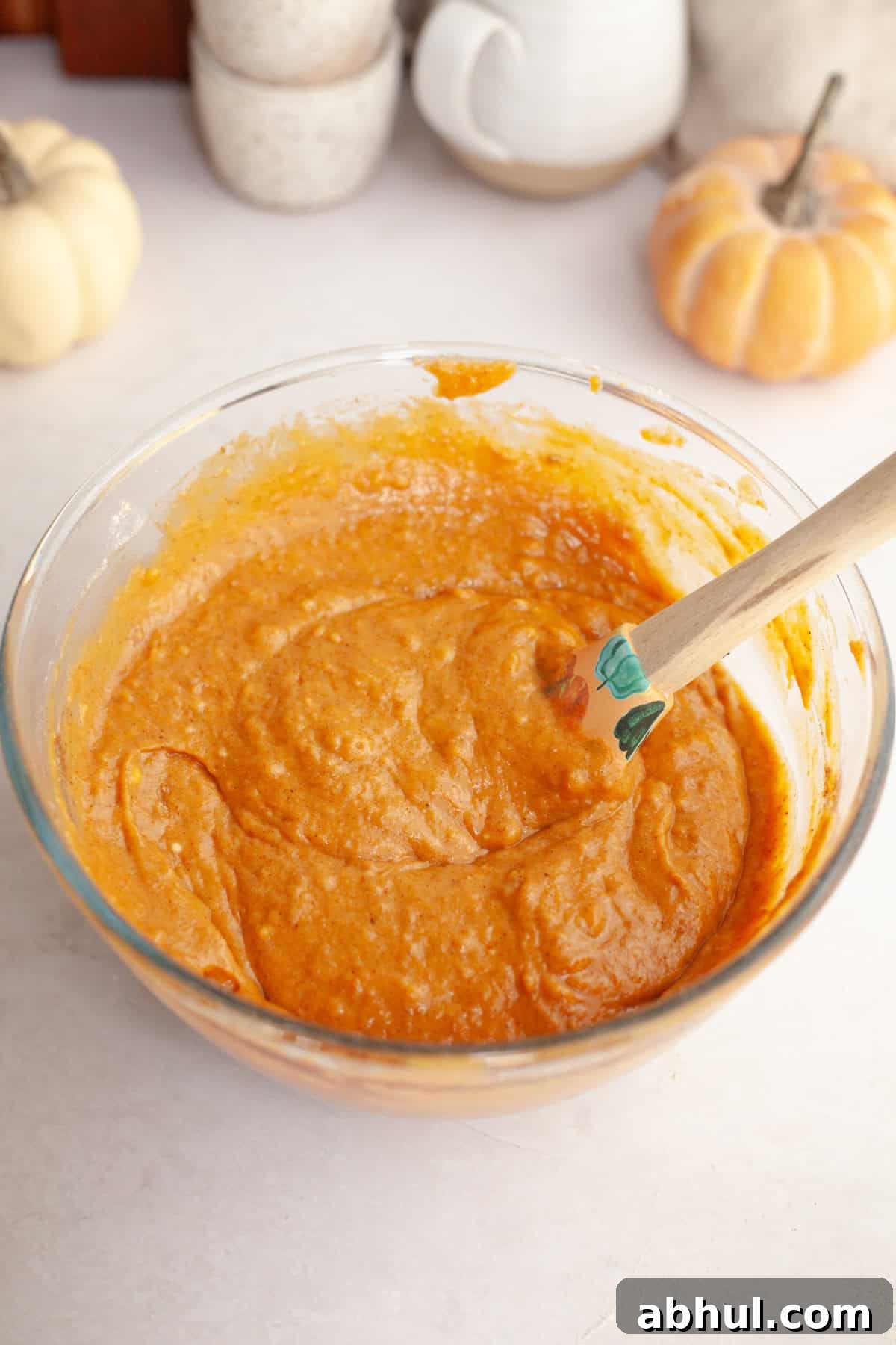 One-Bowl Pumpkin Sour Cream Muffins: Moist Fall Recipe 5 Pumpkin muffin batter in a glass bowl with a rubber spatula.
