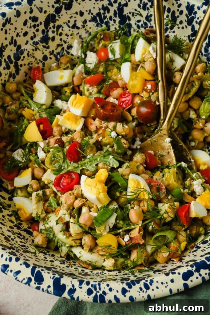 tossed chickpea cobb salad ingredients in large mixing bowl.