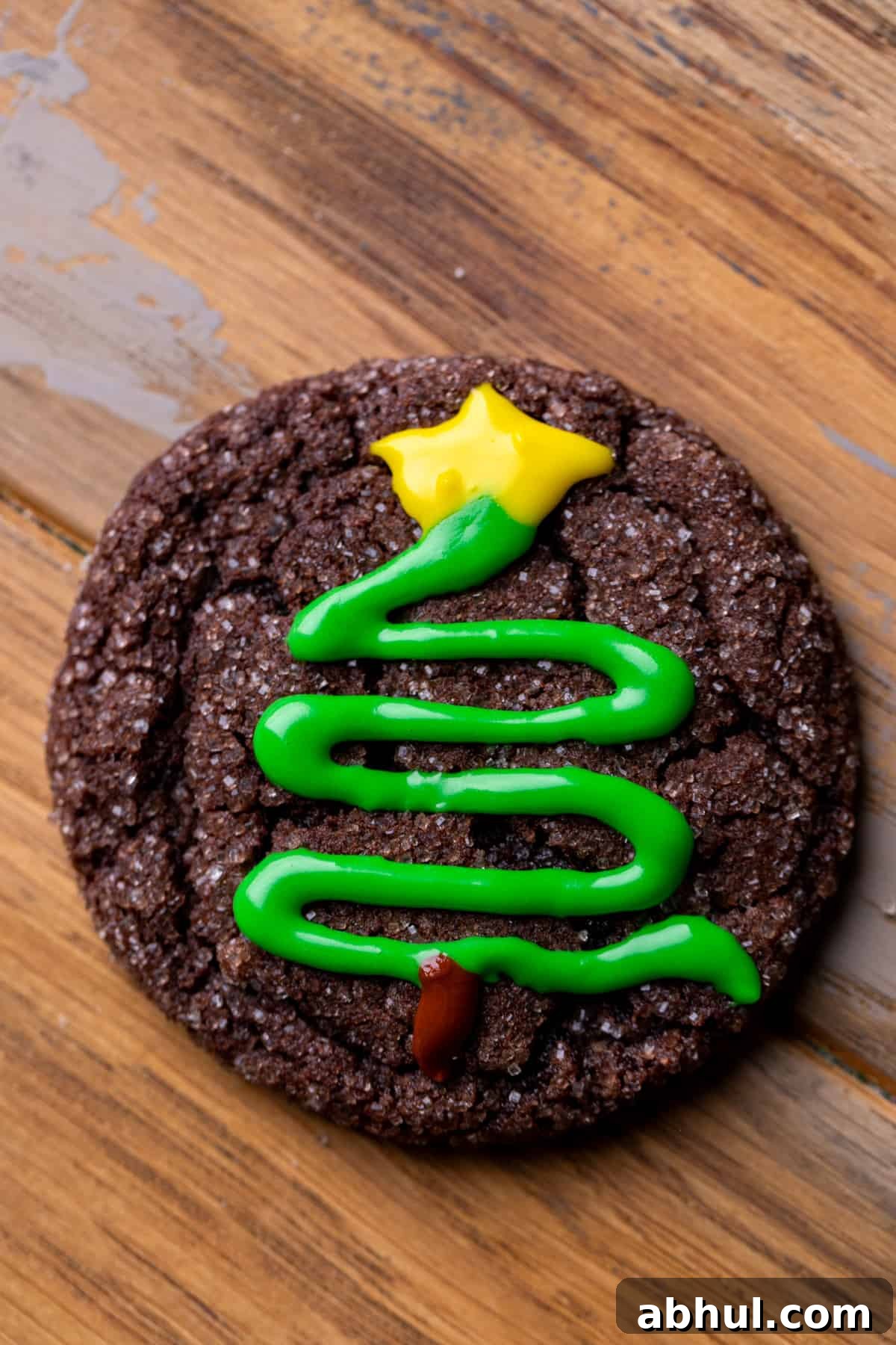 Chocolate cookie with a star on top of the tree with icing.