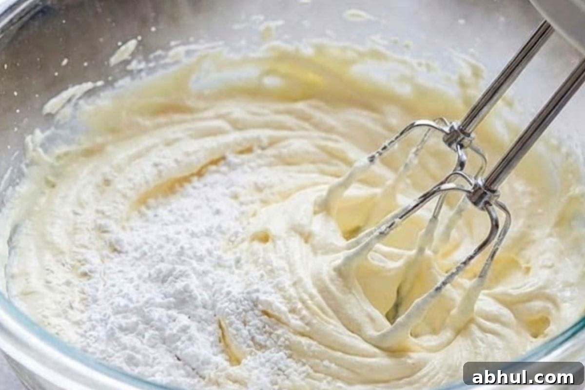 In a separate large bowl, beat the softened cream cheese and powdered sugar 