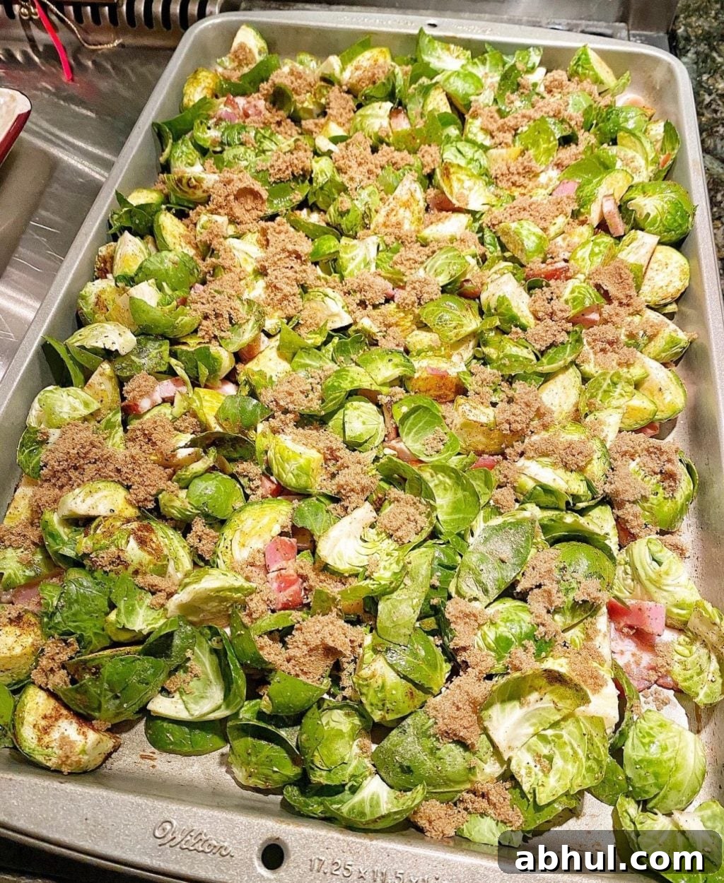 A sheet pan with Brussels Sprouts, with a sprinkle of bacon , brown suagr, about to go into the oven