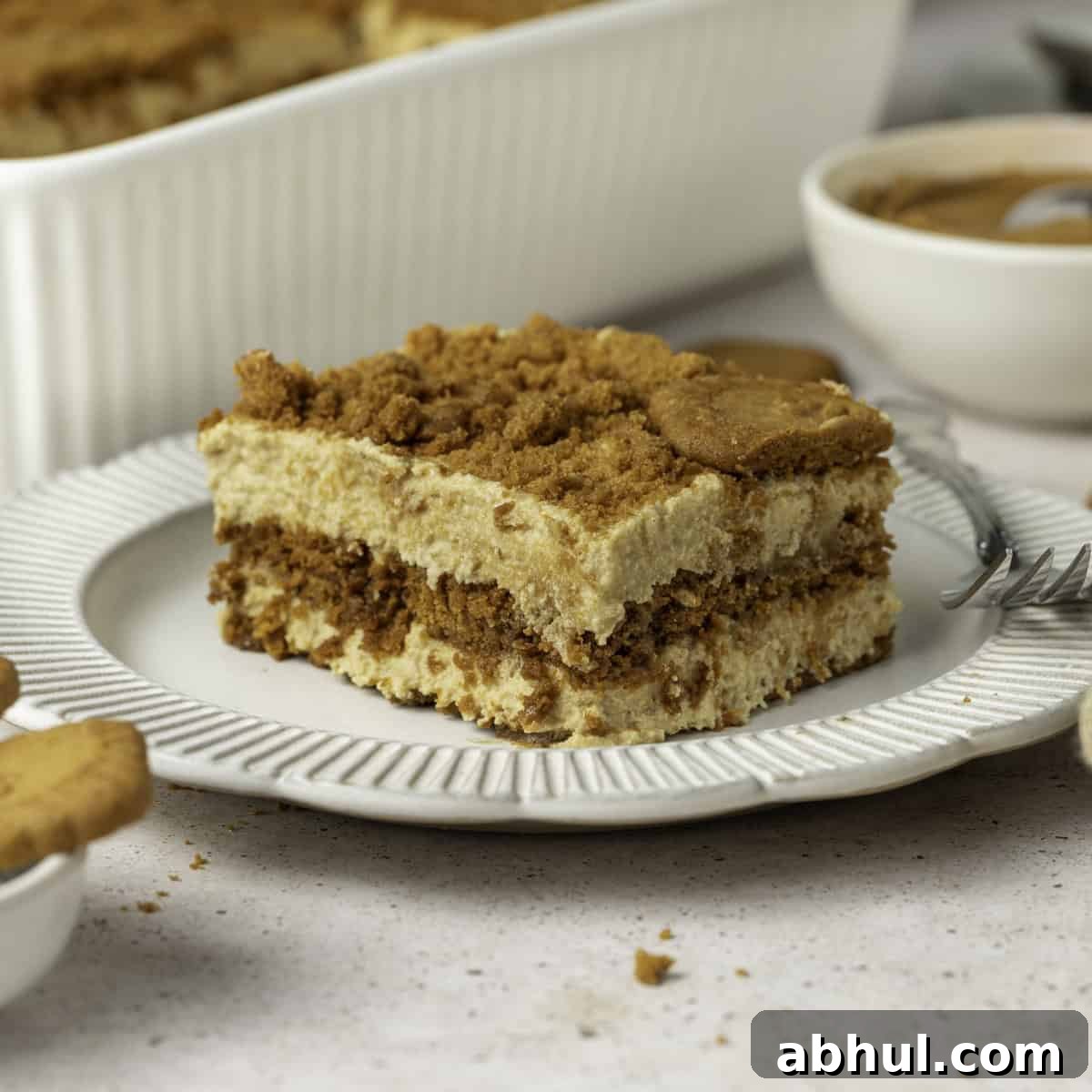 Close up on a slice of speculoos tiramisu on a small white plate.
