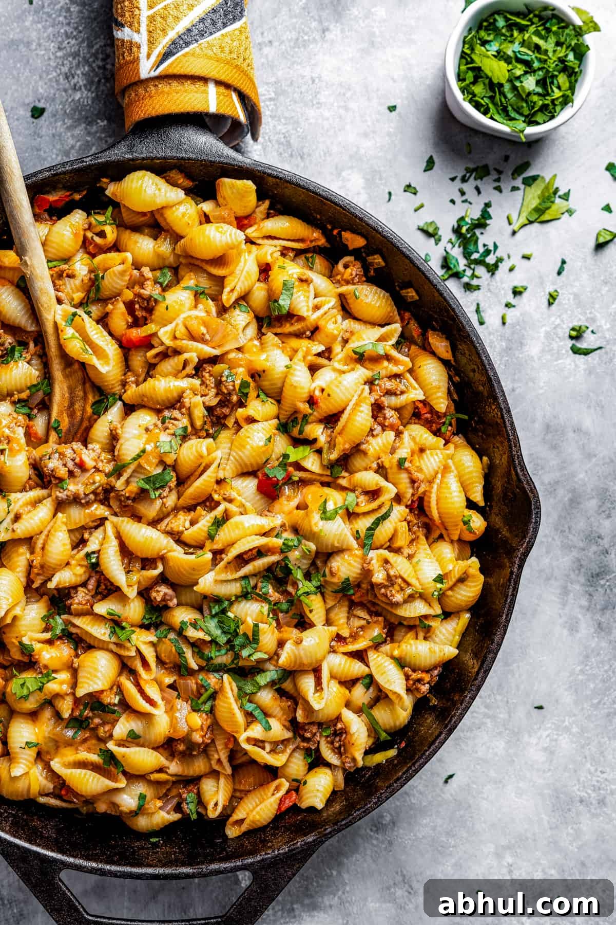 Taco pasta in a skillet with a wooden spoon.