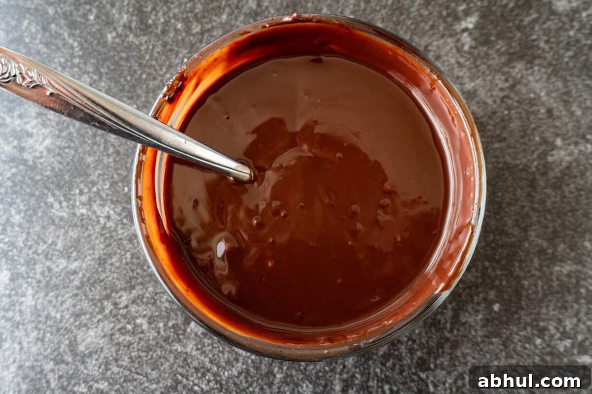 chocolate ganache melted and mixed in a clear glass bowl.
