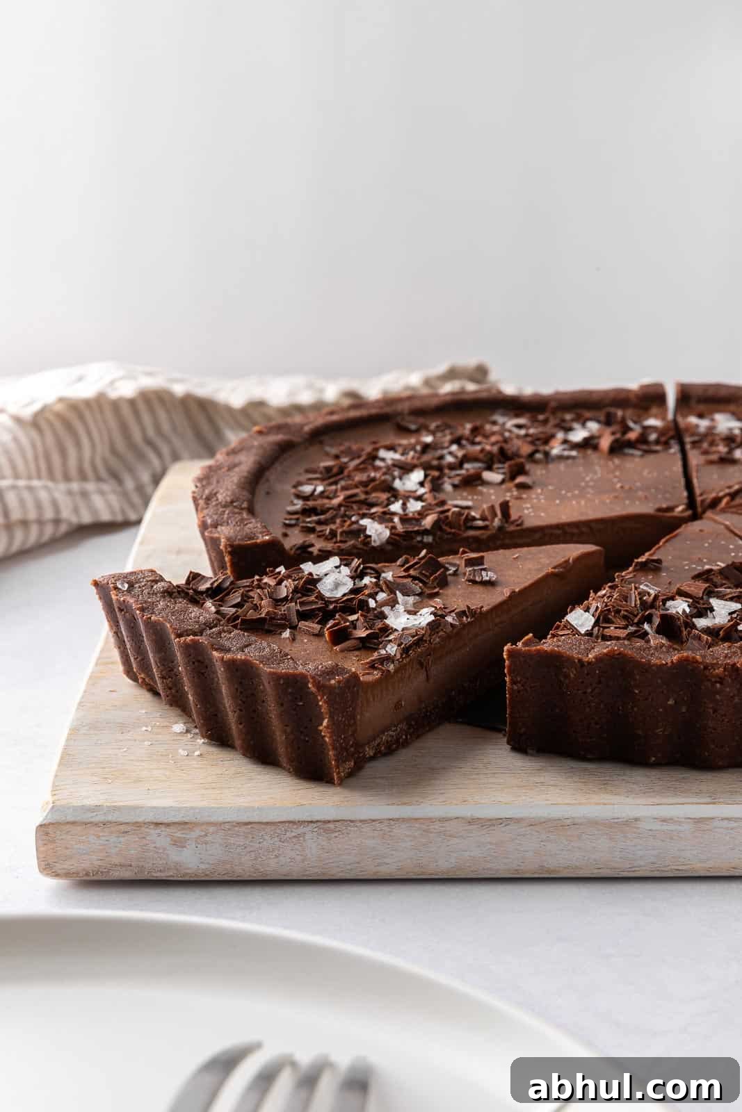 Decadent vegan no bake pie is sliced on a board and ready to serve.