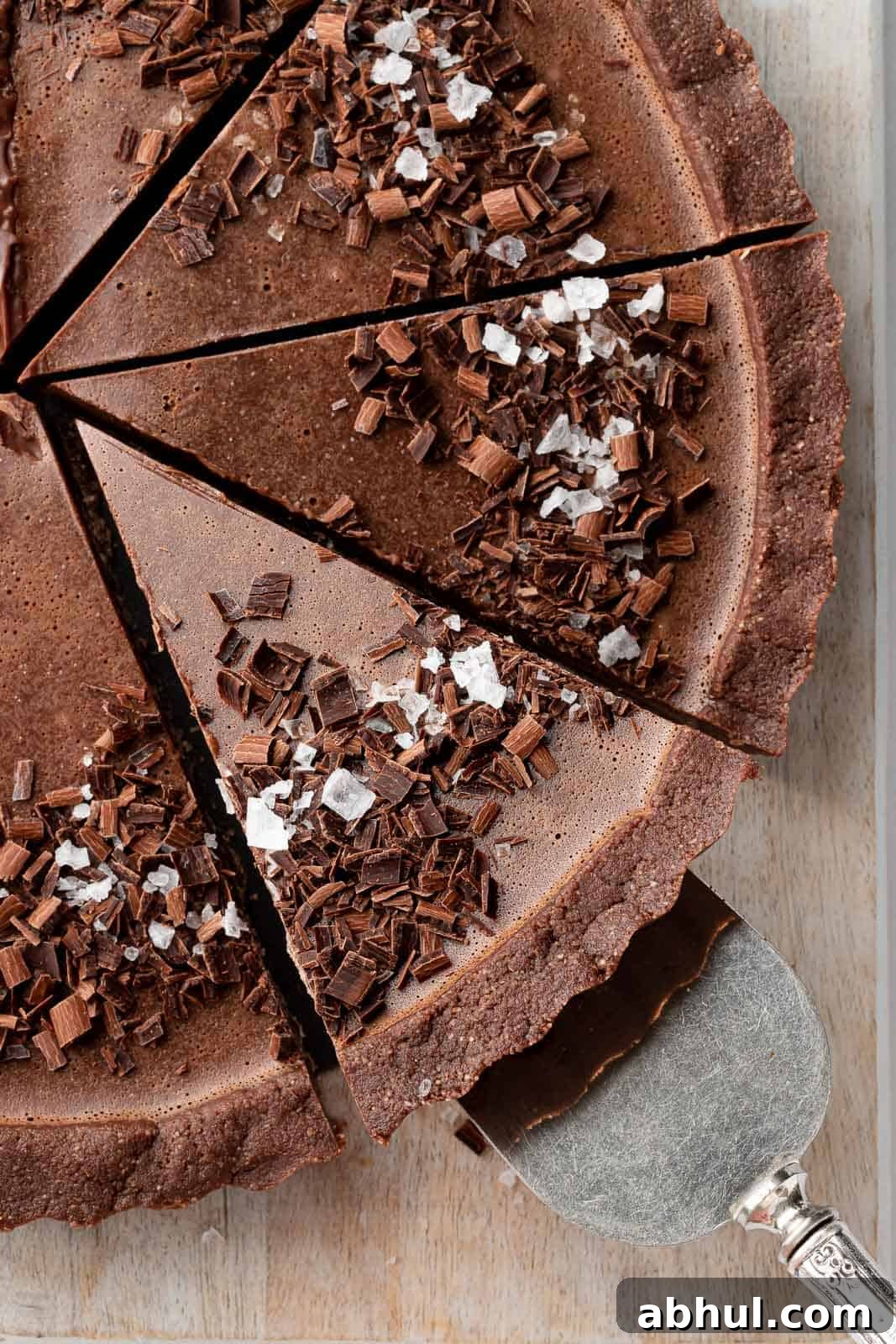 A slice of the best vegan pie is being lifted on a cake serving knife.