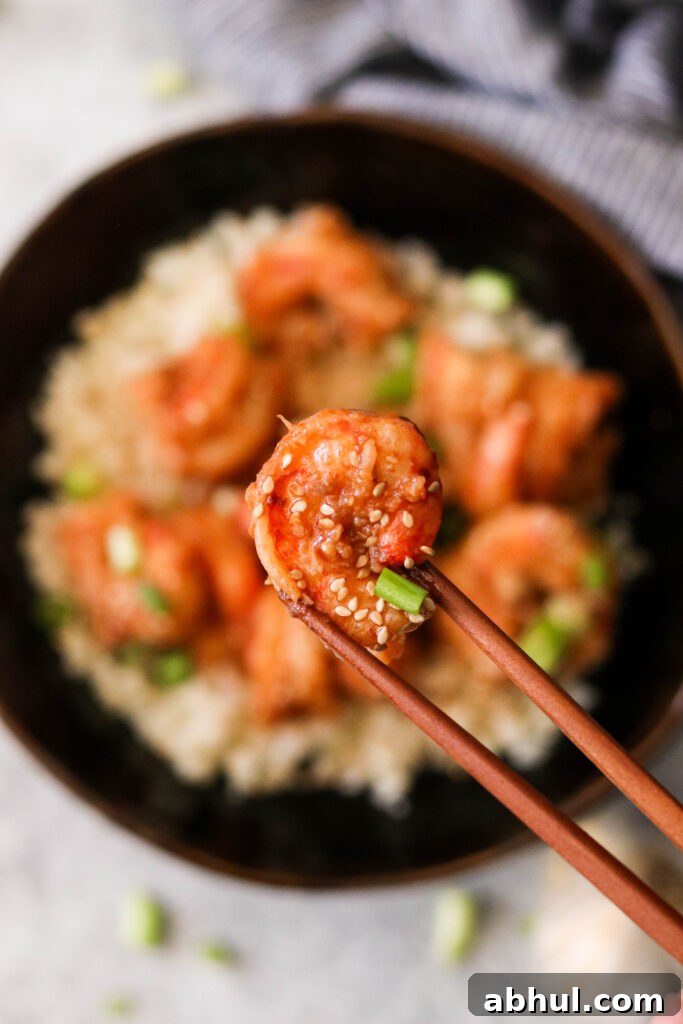 Lifting a shrimp in garlic chili sauce with chopsticks