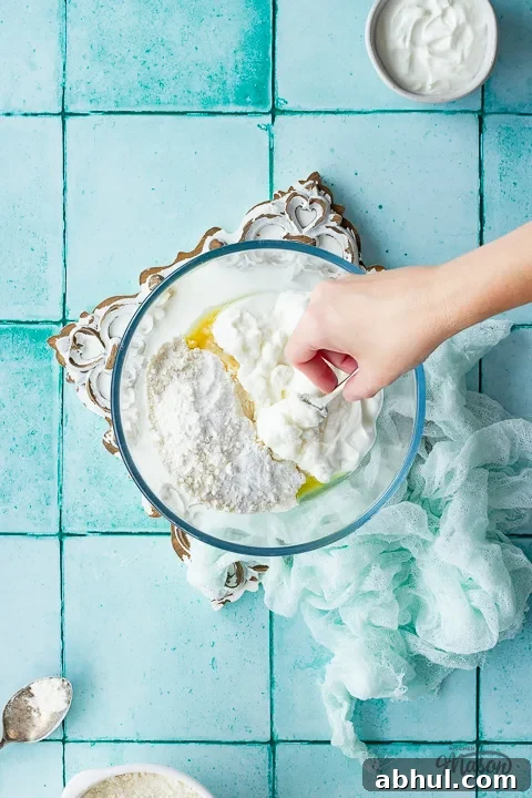 Someone mixing pizza dough ingredients together in a bowl
