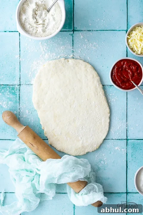 Pizza dough rolled out on a floured surface