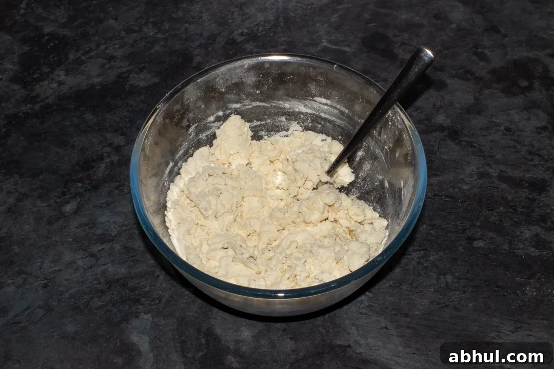 Quick pizza dough in a mixing bowl with a fork