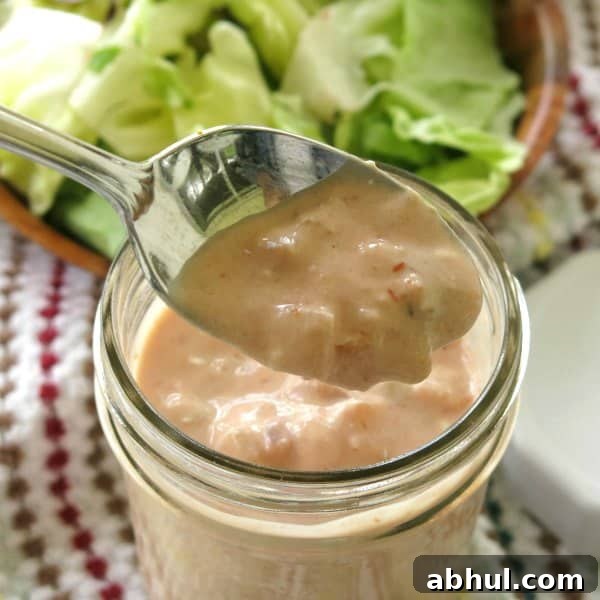 Spoon lifting Healthy Taco Salad Dressing out of mason jar