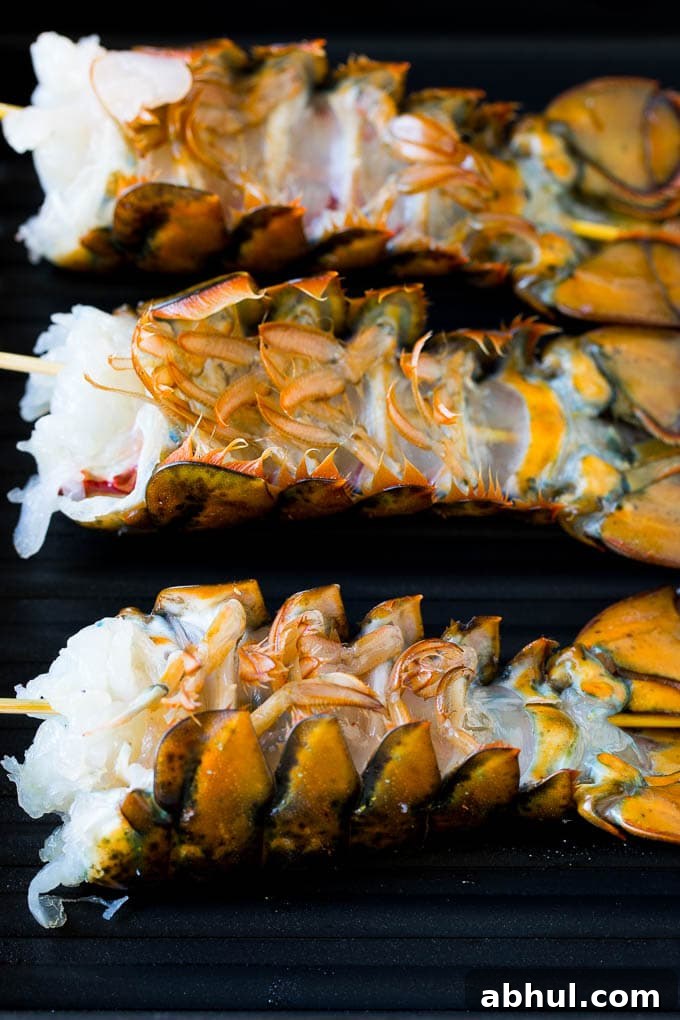 Lobster tails upside down on a grill pan.