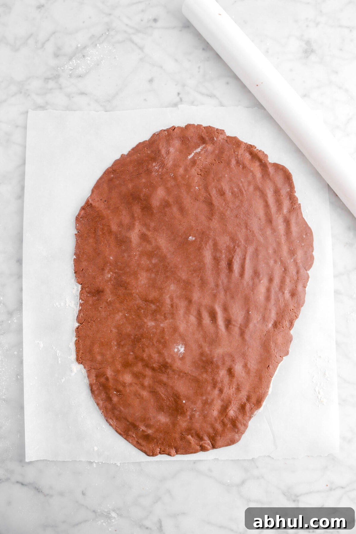 Chocolate-Strawberry Linzer Cookie Recipe for Perfect Sandwich Cookies 19 rolled out cookie dough on floured parchment with white rolling pin