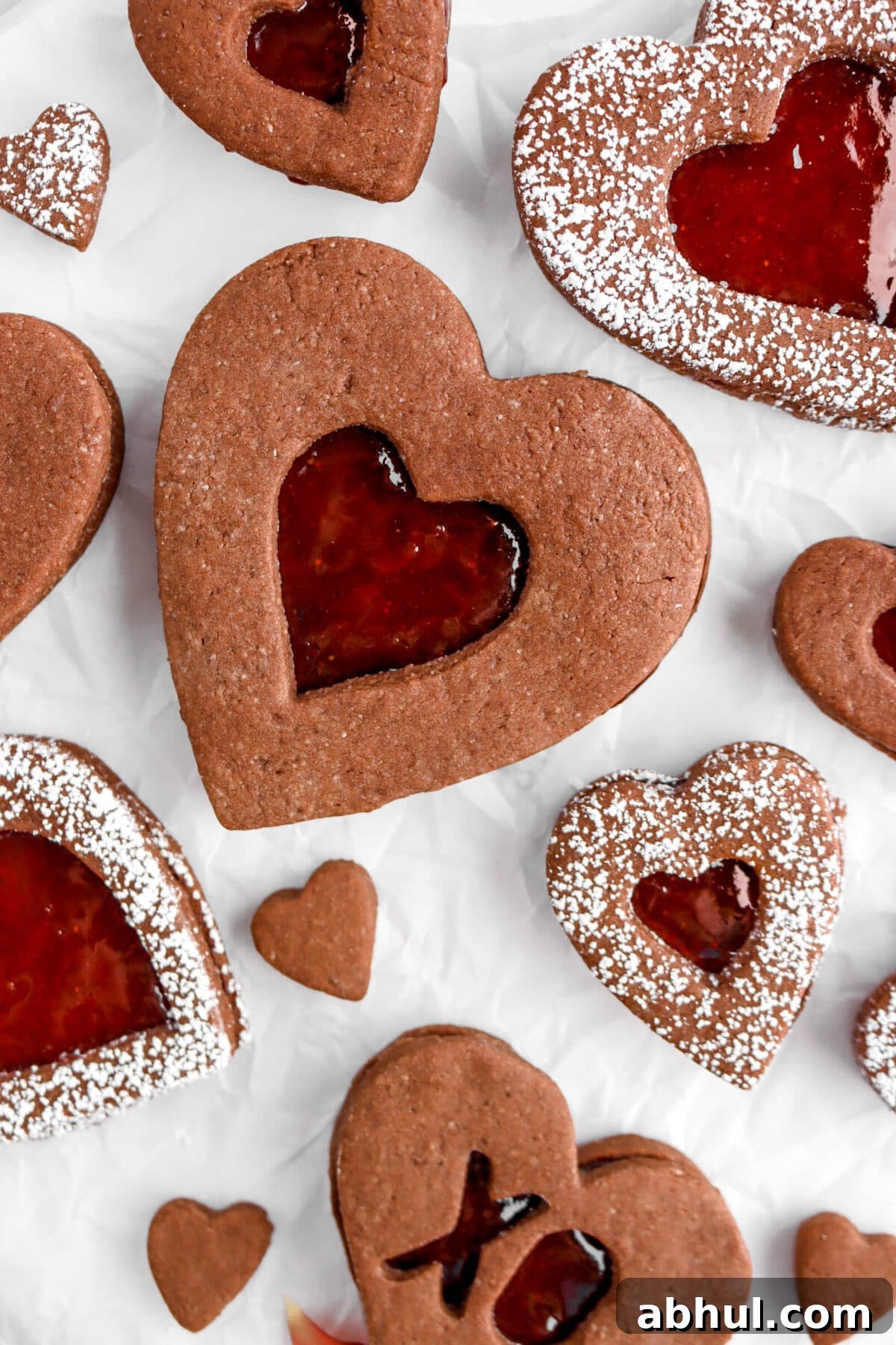 Chocolate-Strawberry Linzer Cookie Recipe for Perfect Sandwich Cookies 3 close up of chocolate heart shaped linzer cookie on parchment paper