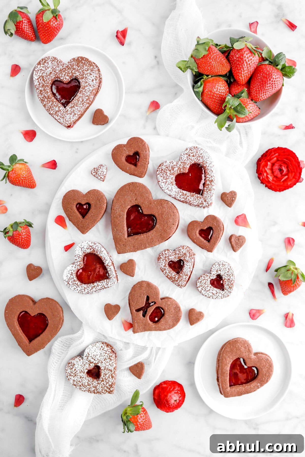 Chocolate-Strawberry Linzer Cookie Recipe for Perfect Sandwich Cookies 27 overhead shot of heart shaped chocolate linzer cookies with strawberries and red flowers