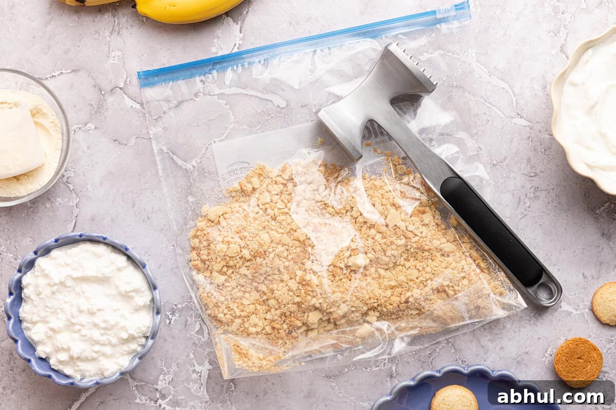 crushed vanilla wafers in a plastic bag with a meat mallet