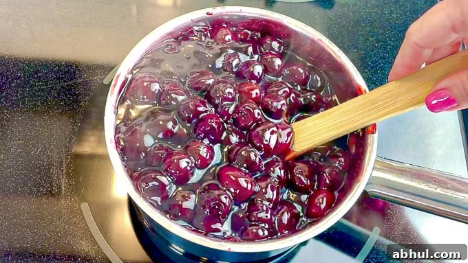 Homemade Cherry Pie Filling being stirred in a sauce pan