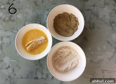 Egg wash the flour coated fish finger.