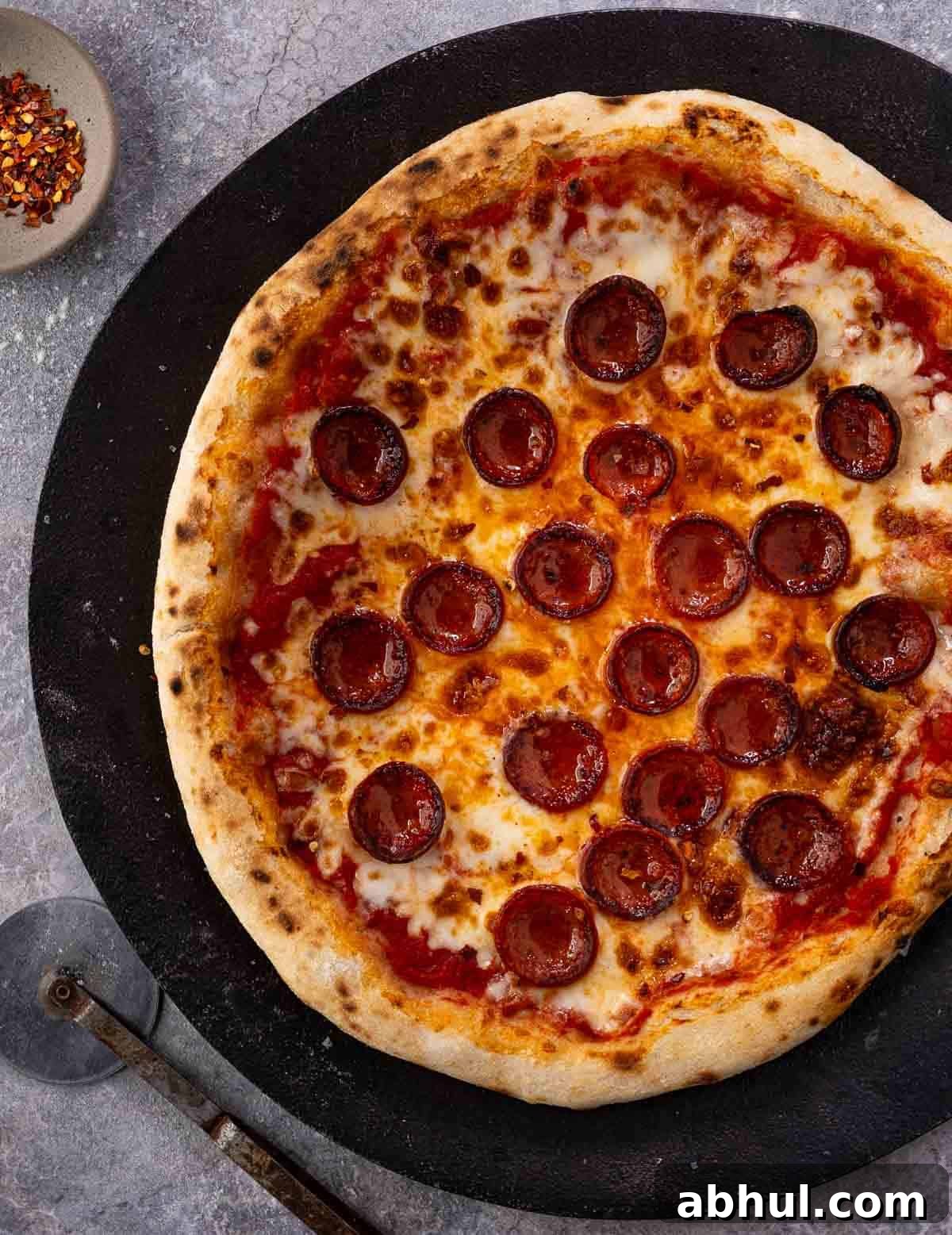 A pepperoni pizza made with a Sourdough Pizza Dough on a serving platter