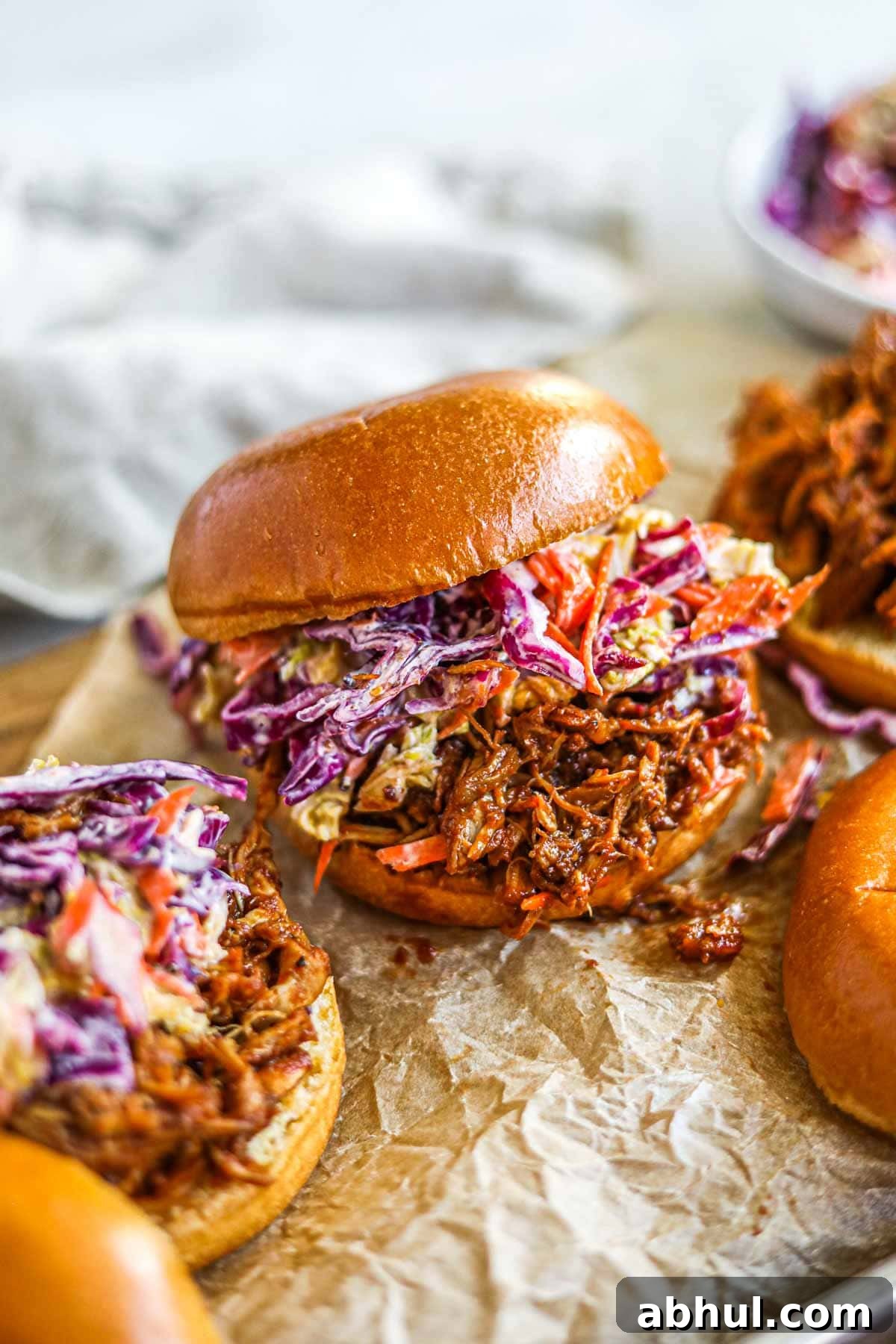 Slow cooker BBQ pulled chicken burgers (sandwiches and sliders) with homemade cabbage coleslaw.