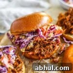 Slow cooker BBQ pulled chicken burgers (sandwiches and sliders) with homemade cabbage coleslaw.