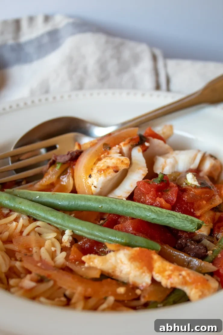 Mediterranean Baked Fish, in serving bowl with orzo pasta.