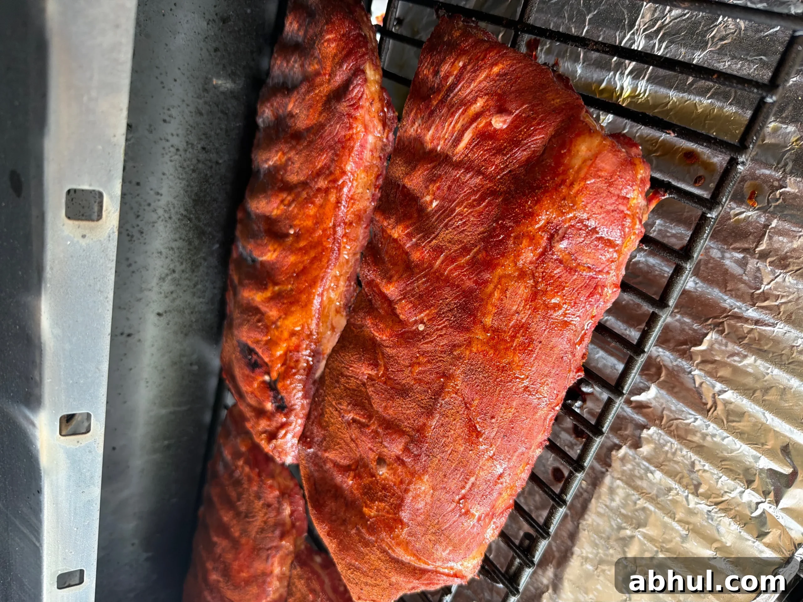 Smoked ribs with red dry rub cooking on pellet grill grates